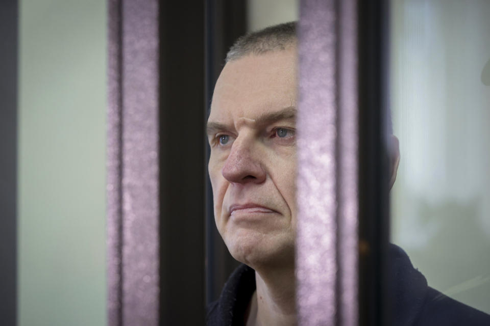 Journalist Andrzej Poczobut stands in a defendants' cage during a court session in Grodno, Belarus, Monday, Jan. 16, 2023. Belarus on Monday opened the trial of a journalist and prominent member of the country's sizable Polish minority, the latest in a series of court cases against critics of the authoritarian regime of President Alexander Lukashenko. (Leonid Shcheglov/Pool via AP)