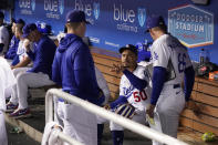Members of the Los Angeles Dodgers wait in the dugout after a drone was seen above the field during the third inning of a baseball game against the Colorado Rockies Tuesday, Oct. 4, 2022, in Los Angeles. The game was halted for several minutes due to the intrusion. (AP Photo/Mark J. Terrill)