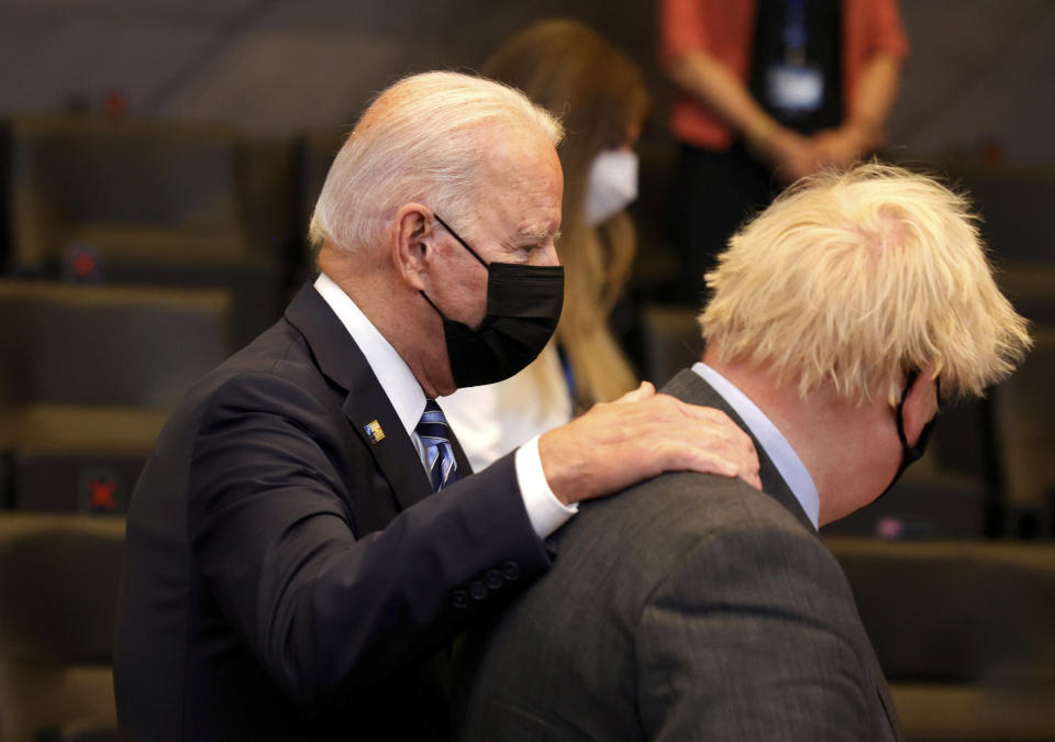 U.S. President Joe Biden, left, speaks with British Prime Minister Boris Johnson during a plenary session at a NATO summit in Brussels, Monday, June 14, 2021. U.S. President Joe Biden is taking part in his first NATO summit, where the 30-nation alliance hopes to reaffirm its unity and discuss increasingly tense relations with China and Russia, as the organization pulls its troops out after 18 years in Afghanistan. (AP Photo/Olivier Matthys, Pool)