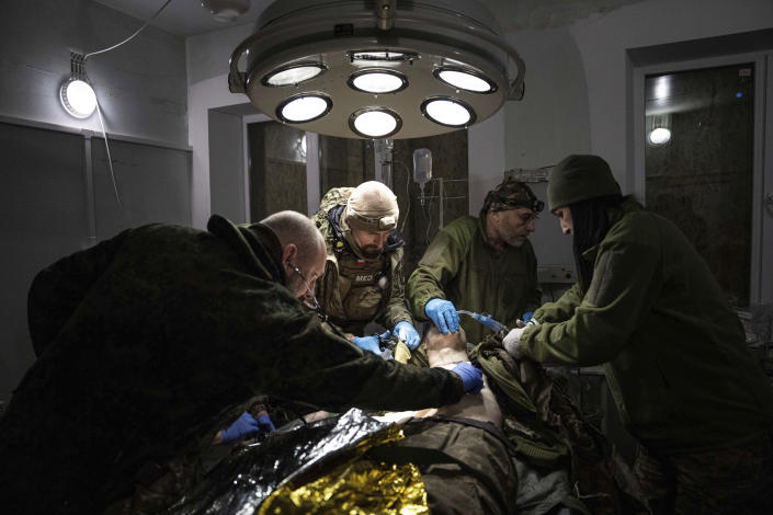 Ukrainian military doctors treat their injured comrade who was evacuated from the battlefield in a hospital in Donetsk region, Ukraine, Monday, Jan. 9, 2023. The serviceman did not survive. (AP Photo/Evgeniy Maloletka)