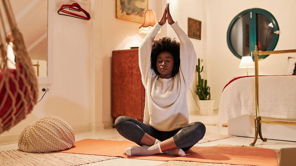 Woman doing yoga stretch in her bedroom