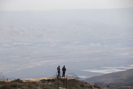 Jewish settlers stand at an observation point overlooking the West Bank village of Duma, near Yishuv Hadaat, an unauthorised Jewish settler outpost January 5, 2016. REUTERS/Ronen Zvulun