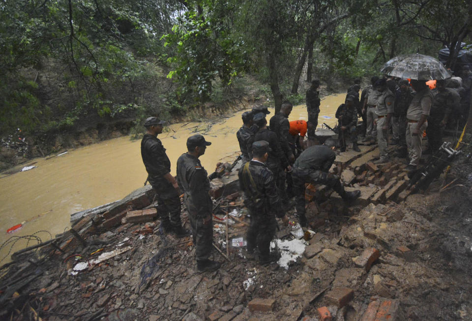 Rescuers work at the site of a wall that collapsed following heavy rains in Lucknow, in the northern Indian state of Uttar Pradesh, Friday, April 16, 2022. The wall collapsed over huts where laborers were sleeping, killing more than 10 people. (AP Photo)