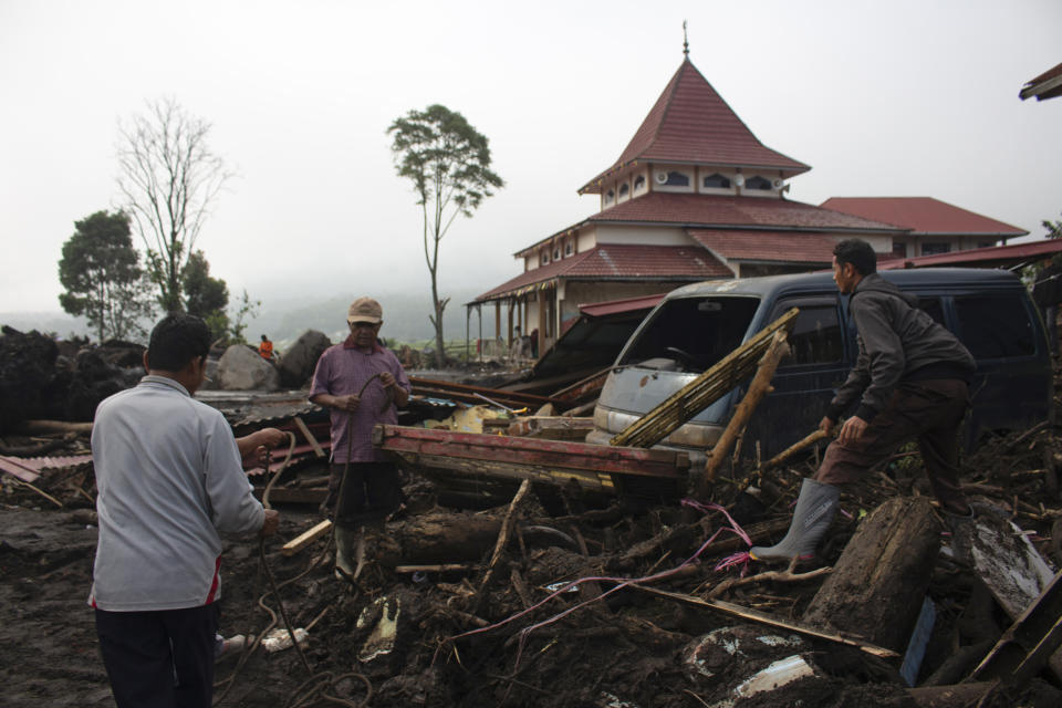 People inspect the damage by a flash flood in Agam, West Sumatra, Indonesia, Tuesday, May 14, 2024. Rescuers on Tuesday searched in rivers and the rubble of devastated villages for bodies, and whenever possible, survivors of flash floods that hit Indonesia's Sumatra Island over the weekend. (AP Photo/Fachri Hamzah)