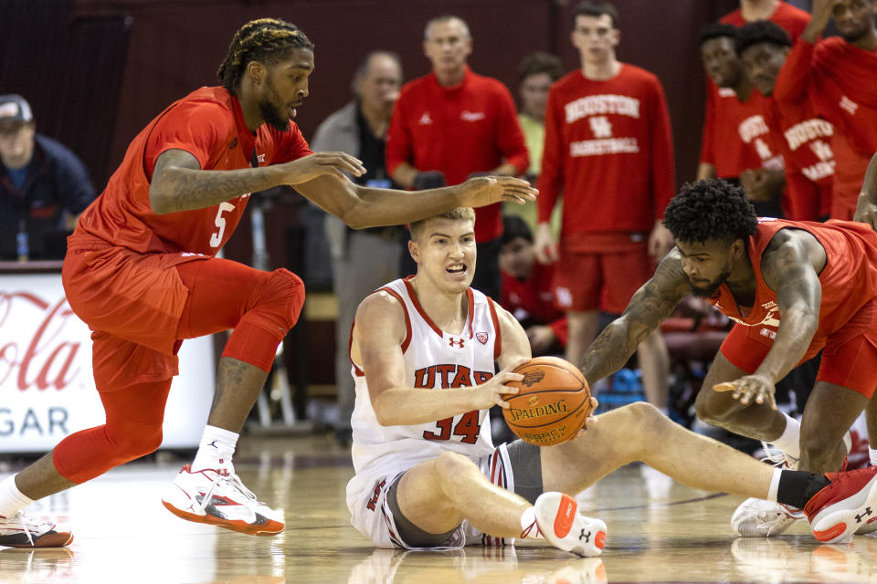 Utah's Lawson Lovering (34) looks to pass the ball against the defense of Houston's Ja'Vier Francis (5) and Jamal Shead, right, in the first half of an NCAA college basketball game during the Charleston Classic in Charleston, S.C., Friday, Nov. 17, 2023. (AP Photo/Mic Smith).