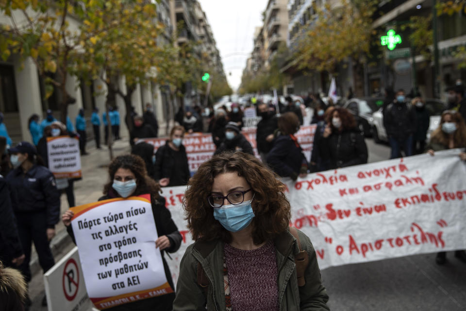 Primary school teachers wearing face masks protest outside Health Ministry demanding more safety measures in schools against the coronavirus pandemic, in Athens, Friday, Jan. 15, 2021. Primary schools and kindergartens reopened this week, but high school lessons are being held online only.Greece's prime minister says the country's retail sector might begin to gradually reopen next week, if the scientists advising the government on the coronavirus pandemic recommend it is safe to do so today. (AP Photo/Petros Giannakouris)