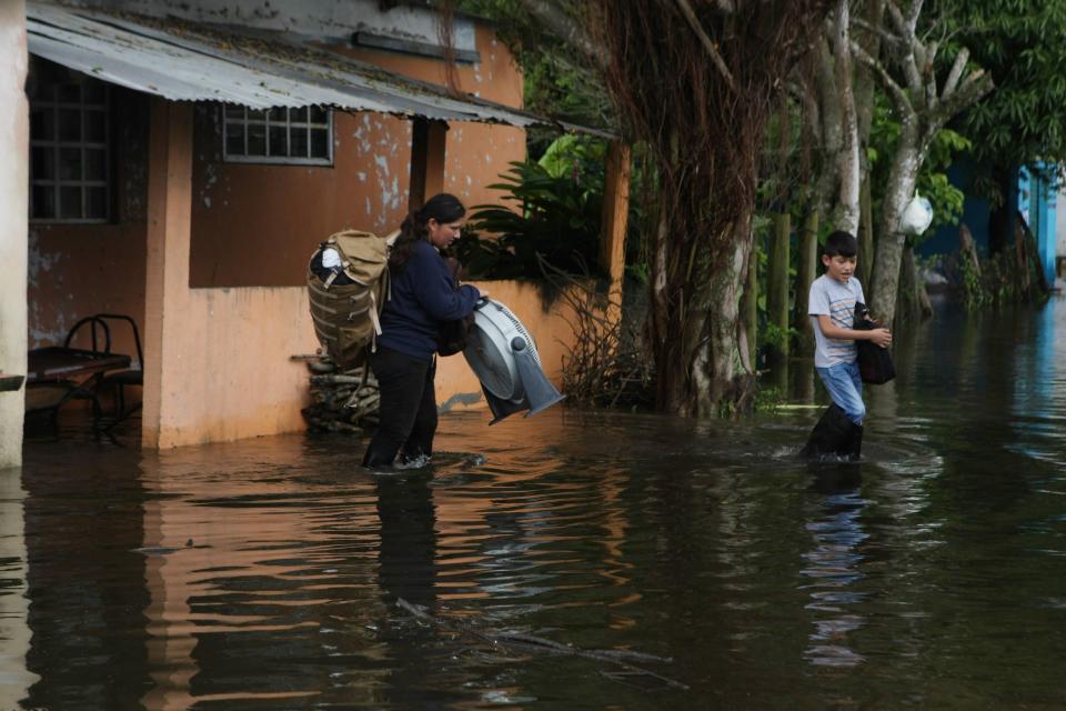 Habitantes de Ixtacomitan abandonan sus hogares debido a las inundaciones por las intensas lluvias.