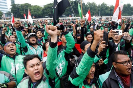 Motorcycle taxi drivers working for online ride-hailing start-ups Grab and Go-jek protest against low tariffs outside parliament in Jakarta, Indonesia, April 23, 2018.   REUTERS/Darren Whiteside