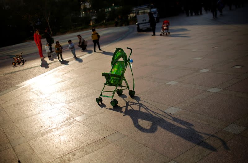 FILE PHOTO: A baby stroller is seen as mothers play with their children at a public area in downtown Shanghai
