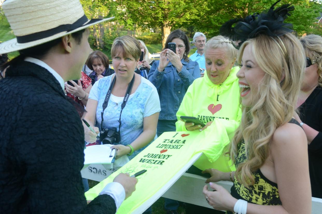 Professional ice skaters Tara Lipinski and Johnny Weir sign t-shirts for Tammy Pickett at the Barnstable-Brown Derby Eve Gala.