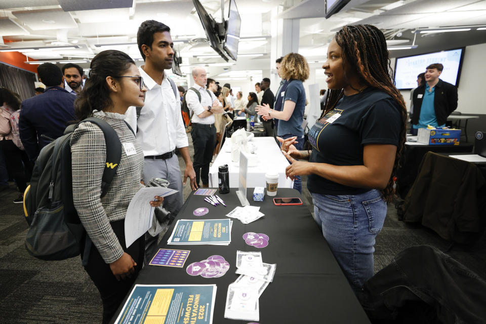 Georgia State University students Kavita Javalagi, left, and Gana Natarajan, second from left, speak with Shetundra Pinkston, during the Startup Student Connection job fair, Wednesday, March 29, 2023, in Atlanta. For the thousands of workers who'd never experienced upheaval in the tech sector, the recent mass layoffs at companies like Google, Microsoft, Amazon and Meta came as a shock. Now they are being courted by long-established employers whose names aren't typically synonymous with tech work, including hotel chains, retailers, investment firms, railroad companies and even the Internal Revenue Service. (AP Photo/Alex Sliz)