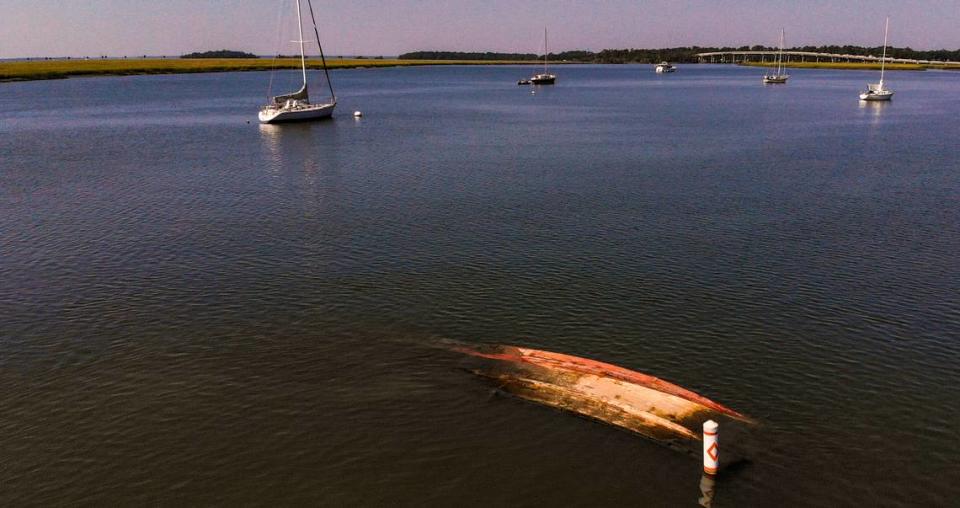 An abandoned, sunken boat is seen at low tide on Wed., Sept. 21, 2022 in Battery Creek with buoy markers to alert boaters near the shrimp dock in the Town of Port Royal.