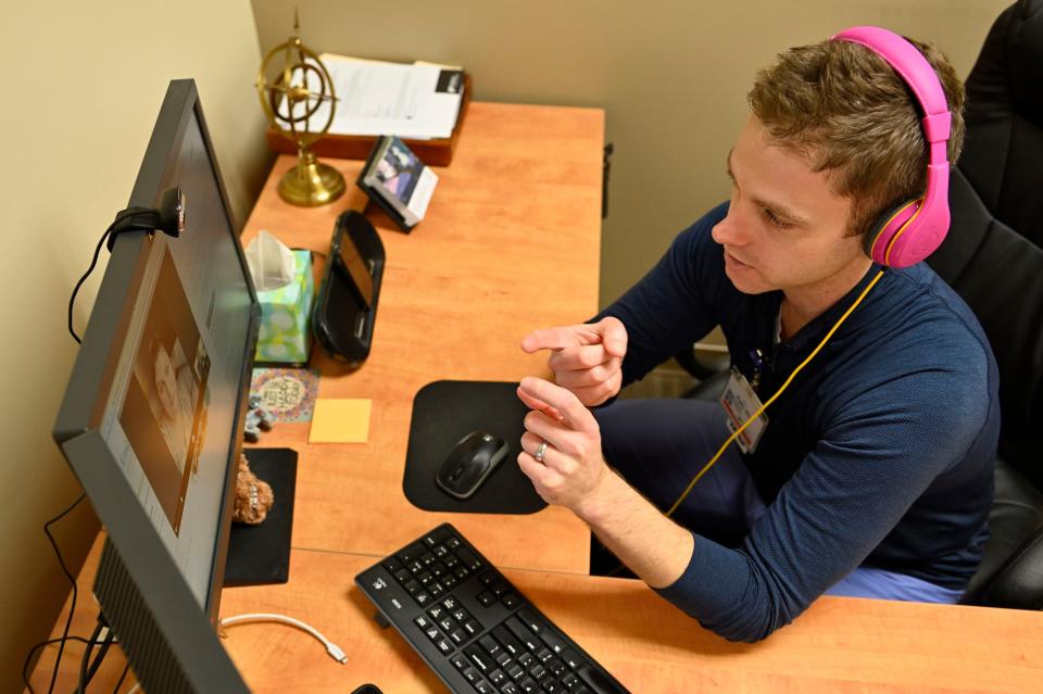 Dr. Brian Plato, a neurologist with Norton Healthcare, meets with a patient through a telehealth visit in his office.