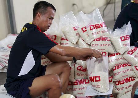 A member of the Philippine Armed Forces help volunteers repack food rations for victims of Typhoon Noul, at the Department of Social Welfare Development (DSWD) headquarters in Pasay city, south of Manila May 9, 2015. REUTERS/Romeo Ranoco