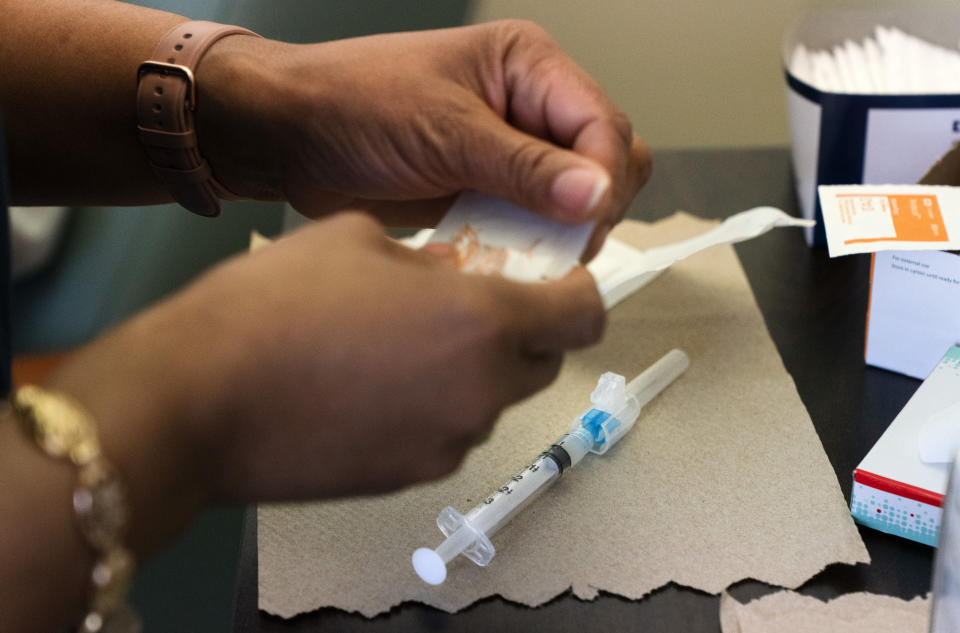 In this Wednesday, Feb. 10, 2021, photo nurse Michelle Martin prepares a COVID-19 vaccination for Wallace Charles Smith, 72, who is a pastor at Shiloh Baptist Church at United Medical Center in southeast Washington. (AP Photo/Jacquelyn Martin)