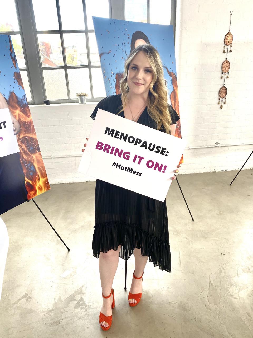 Jess Moore says early menopause affected her so deeply, she is now on a mission to help other women. Jess holding: Menopause: Bring It On! sign. (Supplied)