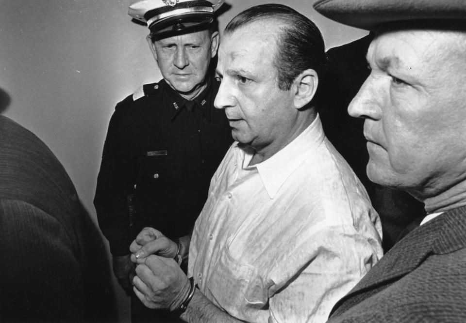 <p>Nightclub owner Jack Ruby is led through the Dallas city jail on his way to his arraignment in Dallas on Nov. 24, 1963. Ruby was charged in the murder of Lee Harvey Oswald, the suspect accused of assassinating President John F. Kennedy. Others are unidentified. (Photo: AP) </p>