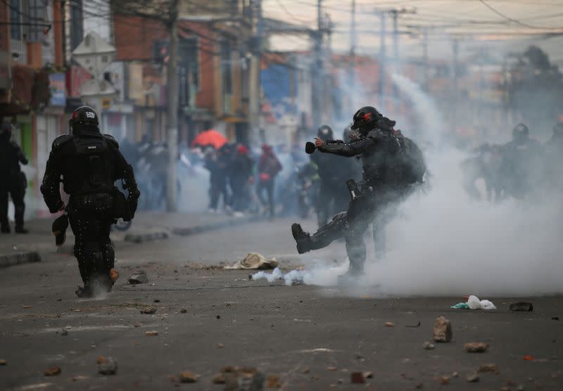 A riot police officer kicks a tear gas canister during clashes with protesters after a man, who was detained for violating social distancing rules, died from being repeatedly shocked with a stun gun by officers, according to authorities, in Bogota