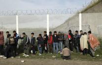 FILE - In this Oct. 27, 2016 file photo, Migrants queue for busses to leave the makeshift migrant camp known as "the jungle" near Calais, northern France. Refugees who stayed at such camps during a 2015 wave of mass migration to Europe have lessons to share with the more than 124,000 people airlifted out of Afghanistan during the U.S.-led evacuation in 2021. (AP Photo/Matt Dunham, File)