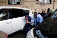 People are evacuated by a member of security forces at the scene where explosions and gunshots were heard at the Dusit hotel compound, in Nairobi, Kenya January 15, 2019. REUTERS/Baz Ratner