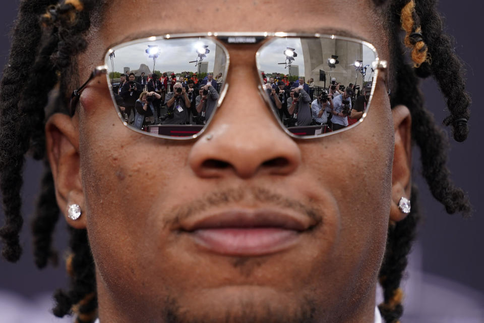 People are reflected in the glasses of Florida quarterback Anthony Richardson on the red carpet before the first round of the NFL football draft, Thursday, April 27, 2023, in Kansas City, Mo. (AP Photo/Charlie Riedel)