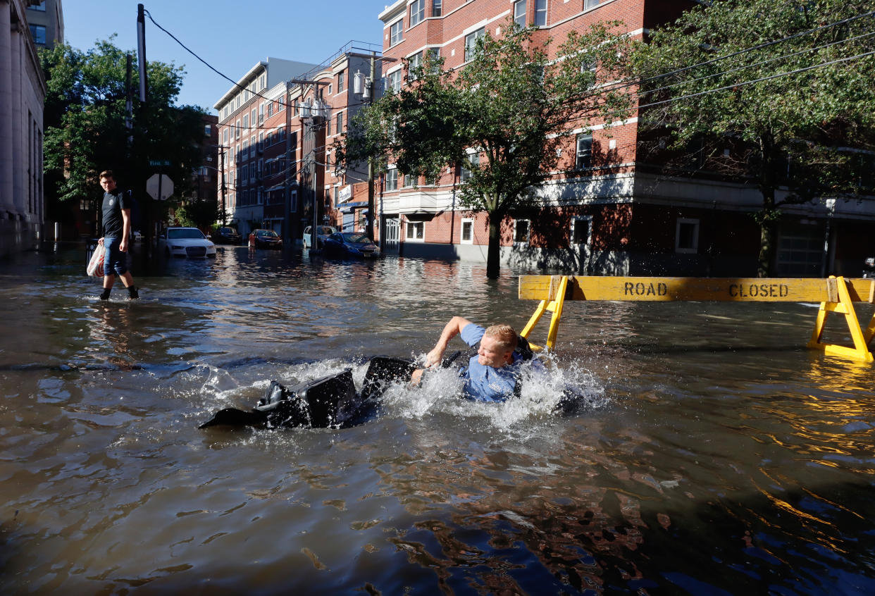 A man in Hoboken, N.J., falls off his bike into a flooded street on Thursday.