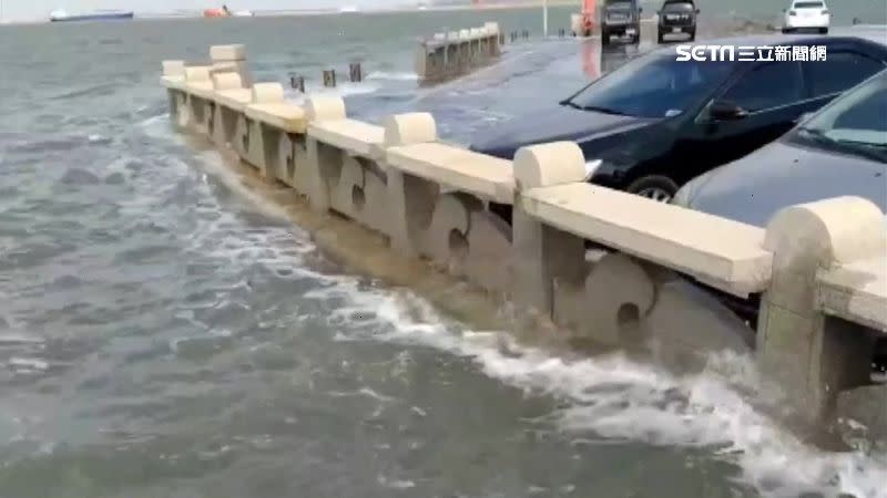 海水淹過堤防，潑灑停放在堤邊車輛。