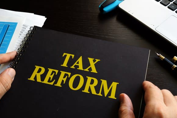 A person holding a binder with the title of tax reform.