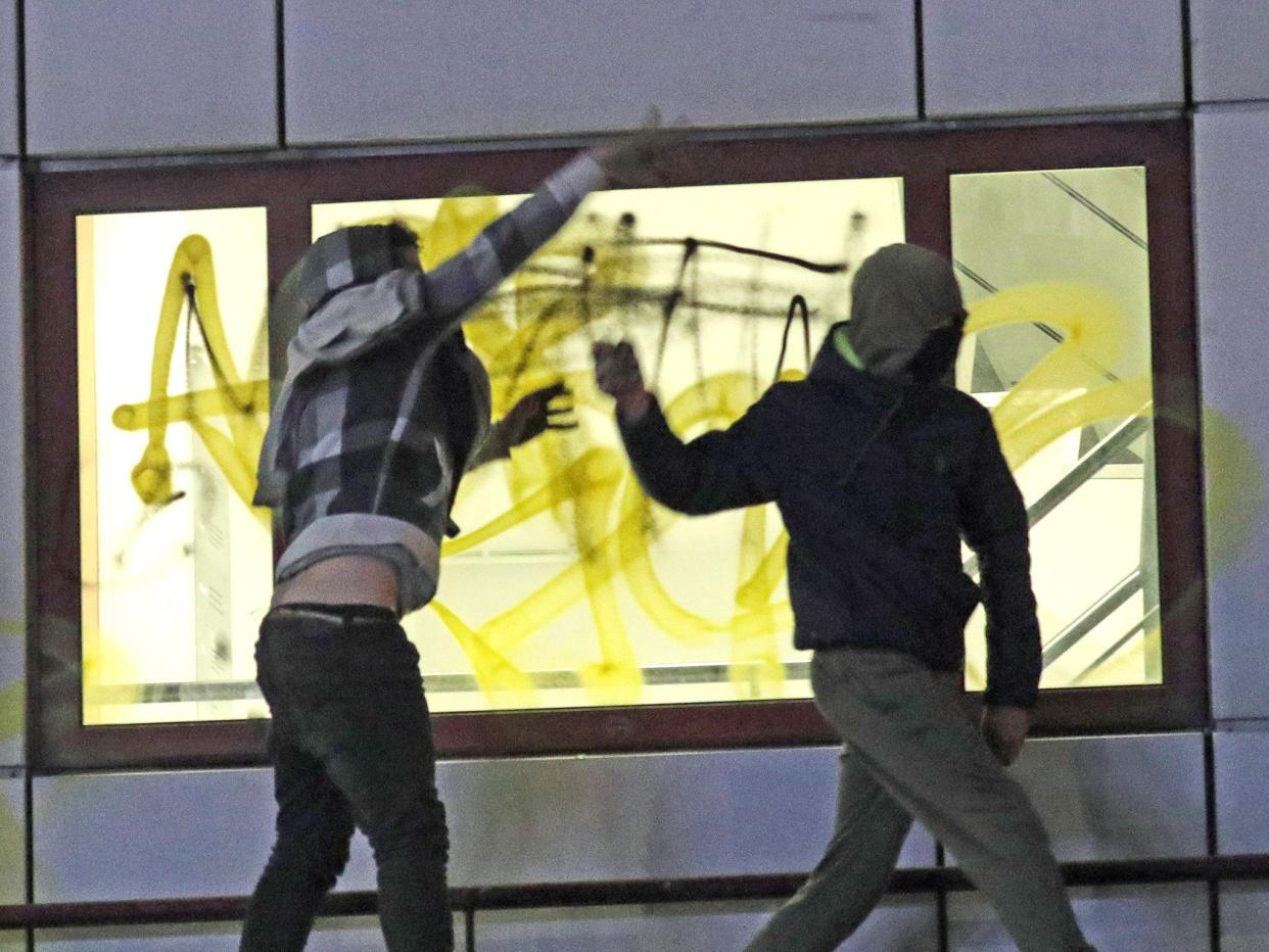 Rioters hurl objects from a roof of Bridewell Police Station on 21 March (PA)