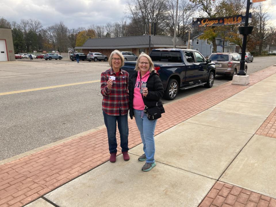 Kelly Gheres and Sandy Webber get ready Tuesday morning to greet voters going to the polls at the community building in Edinboro.