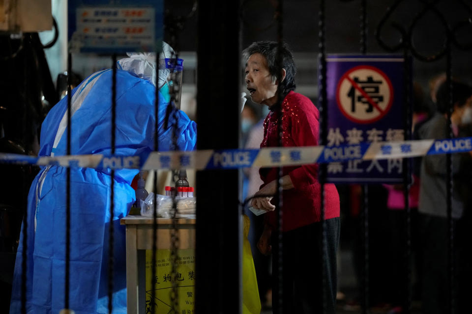 A medical worker in a protective suit collects a swab from a resident for nucleic acid testing, following the coronavirus disease (COVID-19) outbreak in Shanghai, China, November 1, 2022. REUTERS/Aly Song