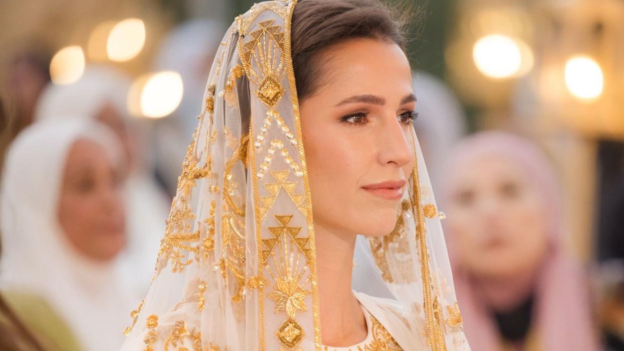 Crown Prince Al Hussein's fiancee Rajwa Alseif in a gold embroidered dress and veil