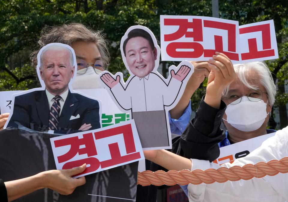 Protesters with images of U.S. President Joe Biden, left, and South Korean President Yoon Suk Yeol stage a rally to denounce policies of the United States on North Korea near the presidential office in Seoul, South Korea, Tuesday, May 17, 2022. Biden will arrive in South Korea on Friday for a three-day visit to hold a summit with Yoon. The signs read 