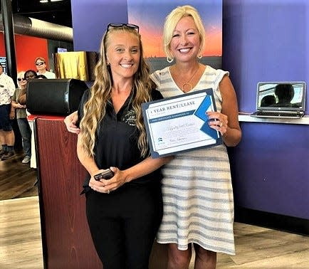 Beth Hannam, Executive Director of the Sandusky County Economic Development Corporation, presents Brandy Kreider with the Grand Prize for The Pitch Competition.