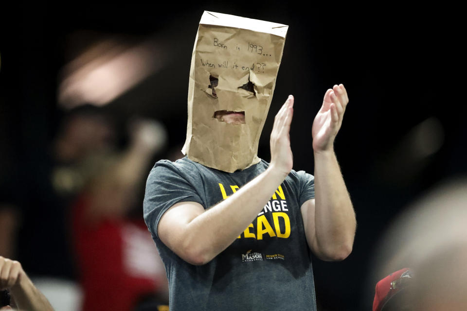 A Pittsburgh Pirates fan wears a paper bag over his head while applauding before the start of the seventh inning of a baseball game against the Washington Nationals, Monday, Aug. 19, 2019, in Pittsburgh. The Pirates were losing 11-0 at the time. (AP Photo/Keith Srakocic)