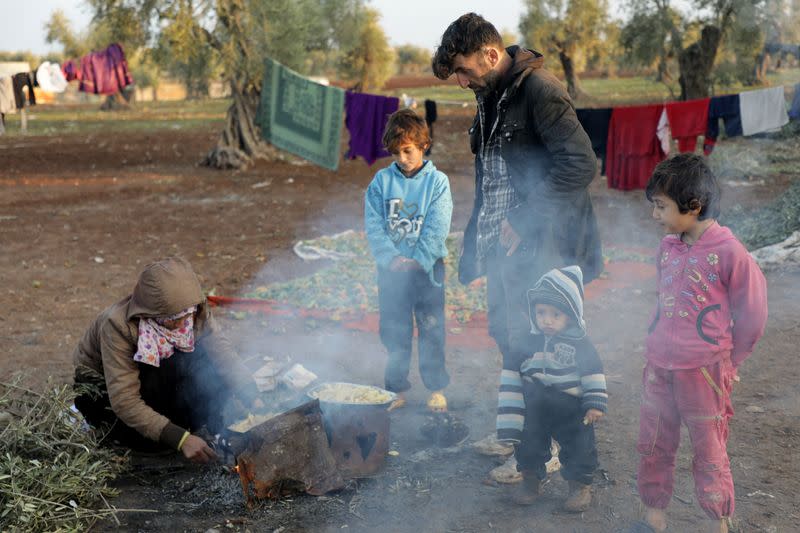 Internally displaced Syrians prepare food at a camp in the Northern Aleppo countryside