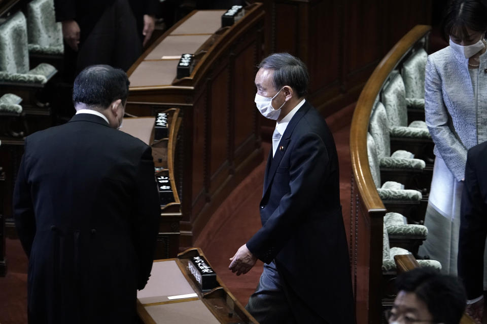 Japan's new Prime Minister Yoshihide Suga, right, leaving after an extraordinary session at the upper house of parliament Thursday, Sept. 17, 2020, in Tokyo. Suga started his first full day in office Thursday, with a resolve to push for reforms for the people, and he said he is already taking a crack at it. (AP Photo/Eugene Hoshiko)