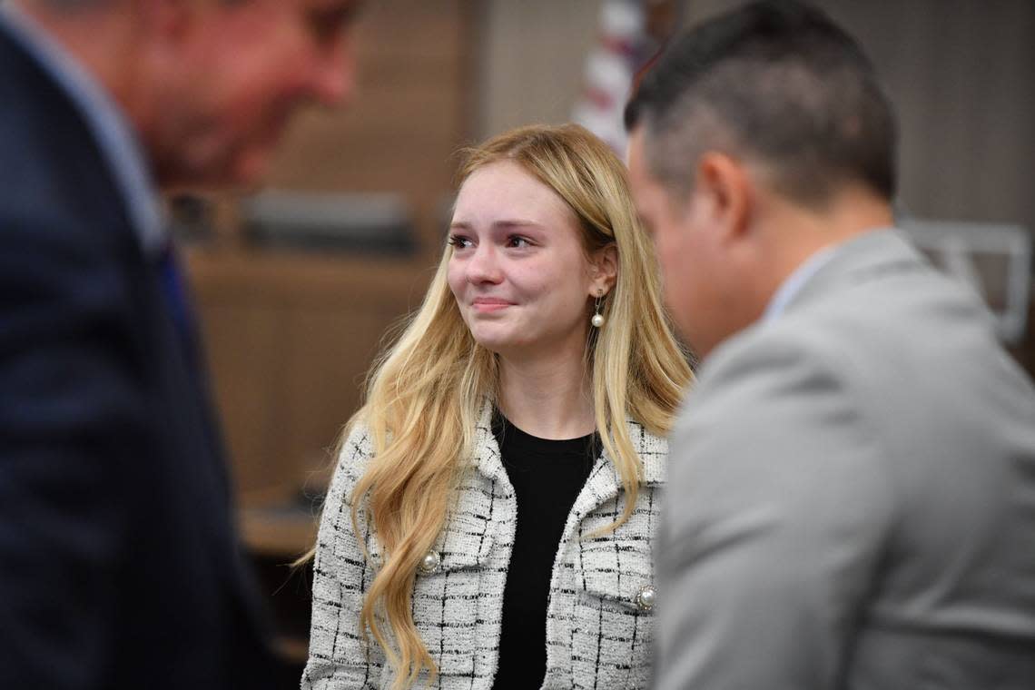 Maya Kowalski smiles at her attorneys after a jury awarded the Kowalski family more than $200 million on Thursday, Nov. 9, 2023. The Kowalski family sued Johns Hopkins All Children’s Hospital for false imprisonment, negligent infliction of emotional distress, medical negligence, battery, and other claims more than a year after the family matriarch, Beata Kowalski, took her life following allegations she was abusing her daughter, Maya Kowalski.