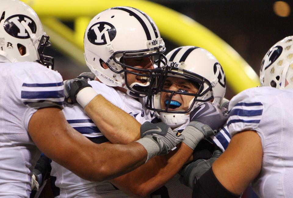 BYU’s Dennis Pitta, left, hugs teammate McKay Jacobson, who snagged the a fourth-quarter touchdown pass against No. 3 Oklahoma that set up Mitch Payne’s game-winning extra point in Cowboys Stadium in 2009. | Scott G. Winterton, Deseret News