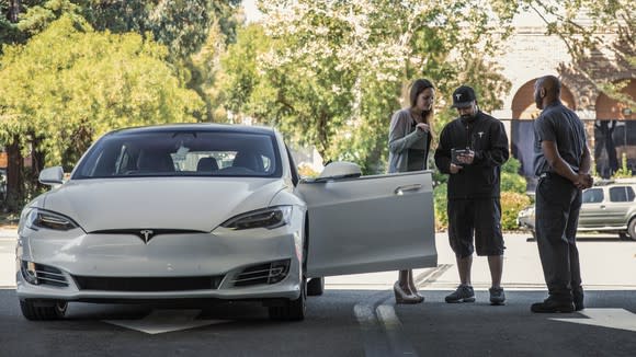 A woman checking in a Model S to a Tesla employee