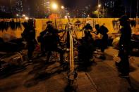 Protesters practice a catapult with stones at the back of a barricade on a road leading to Hong Kong Baptist University