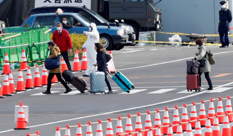 People wheel their luggage as they leave the Daikoku Pier Cruise Terminal in Yokohama, south of Tokyo, Japan