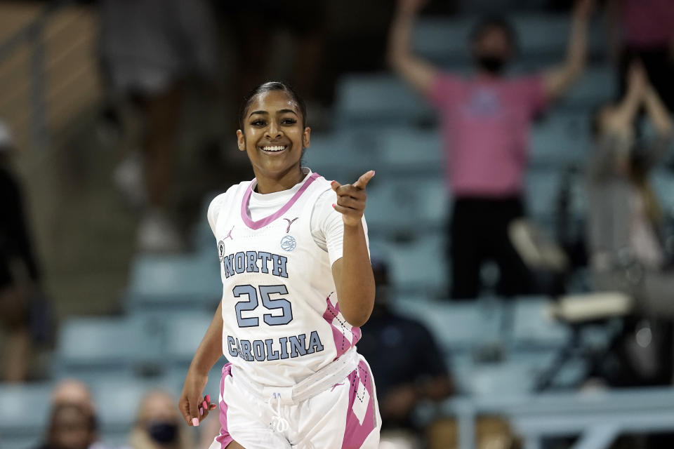 FILE - North Carolina guard Deja Kelly (25) reacts during the first half of an NCAA college basketball game against Louisville in Chapel Hill, N.C., Thursday, Feb. 17, 2022. Some star women’s players have already decided to stay in school rather than make their earliest possible jump to the WNBA and more are on the way with NIL deals and chartered travel offering appeal compared to rookie salaries and commercial flights in the WNBA. (AP Photo/Gerry Broome, File)