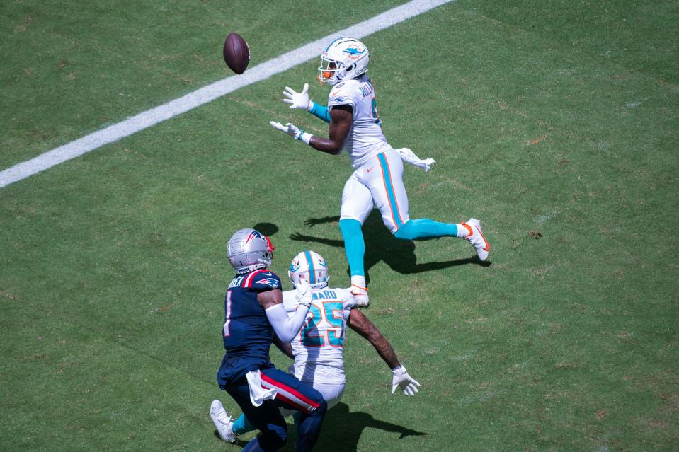 Miami Dolphins safety Jevon Holland (8) catches a tipped pass intended for New England Patriots wide receiver DeVante Parker (1) as Miami Dolphins cornerback Xavien Howard (25) looks on during the first half of the game between the New England Patriots and host Miami Dolphins on Sunday, September 11, 2022, at Hard Rock Stadium in Miami Gardens, FL. Final score, Dolphins, 20, Patriots 7.