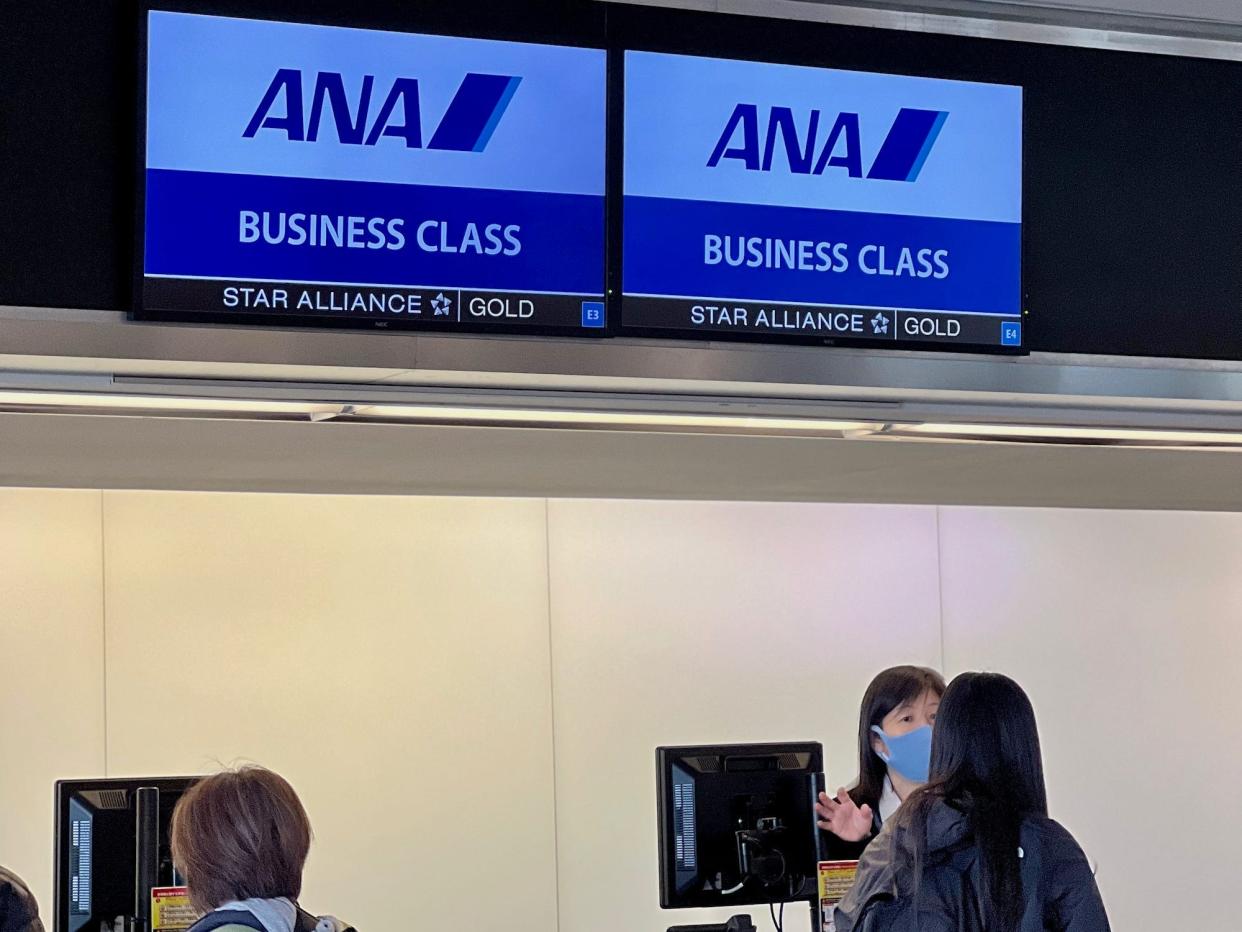 Two ANA business class signs at check-in.