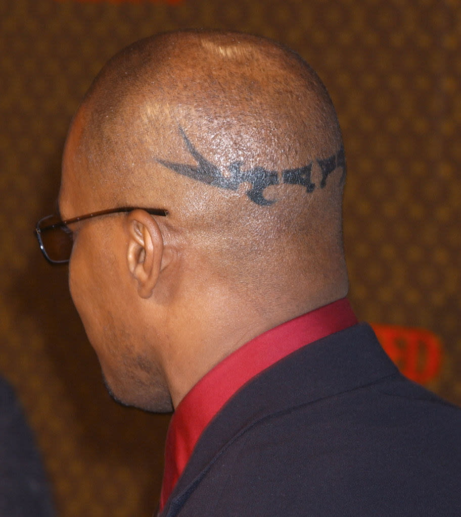 Jamie's bald head showing the decorative horizontal tat on the back