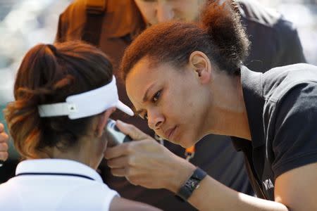 Mar 27, 2017; Miami, FL, USA; Garbine Muguruza of Spain has her temperature checked by a WTA trainer on court against Caroline Wozniacki of Denmark (not pictured) on day seven of the 2017 Miami Open at Crandon Park Tennis Center. Wozniacki won 7-6(1), 0-0 (ret.). Geoff Burke-USA TODAY Sports