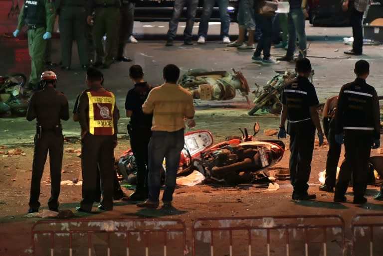 Soldiers and police officers inspect the scene of a bomb blast outside a religious shrine in central Bangkok late on August 17, 2015