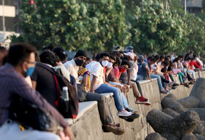 People sit on the promenade at Marine Drive in Mumbai