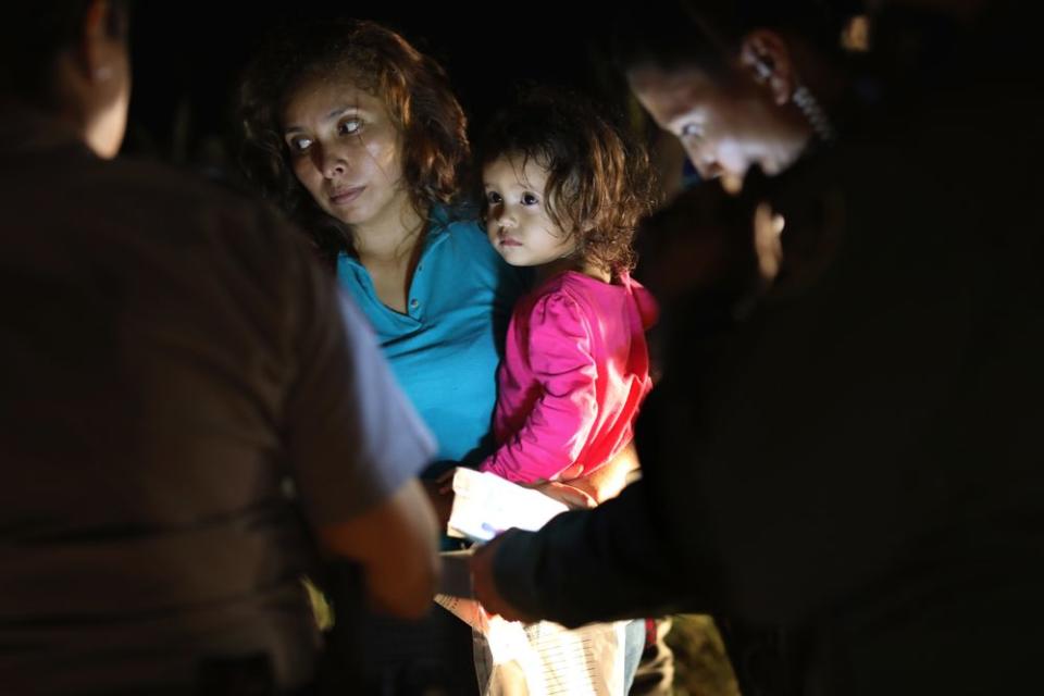 A Honduran mother holds her two-year-old as U.S. Border Patrol as agents review their papers near the U.S.-Mexico border on June 12, 2018 in McAllen, Texas.